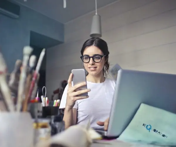 fille-devant-un-ordinateur-et-un-telephone