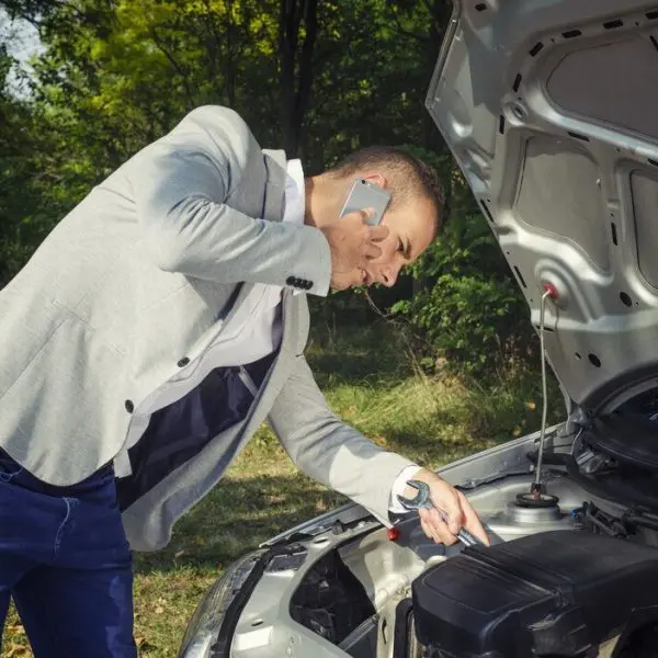 homme-au-telephone-devant-sa-voiture-en-panne