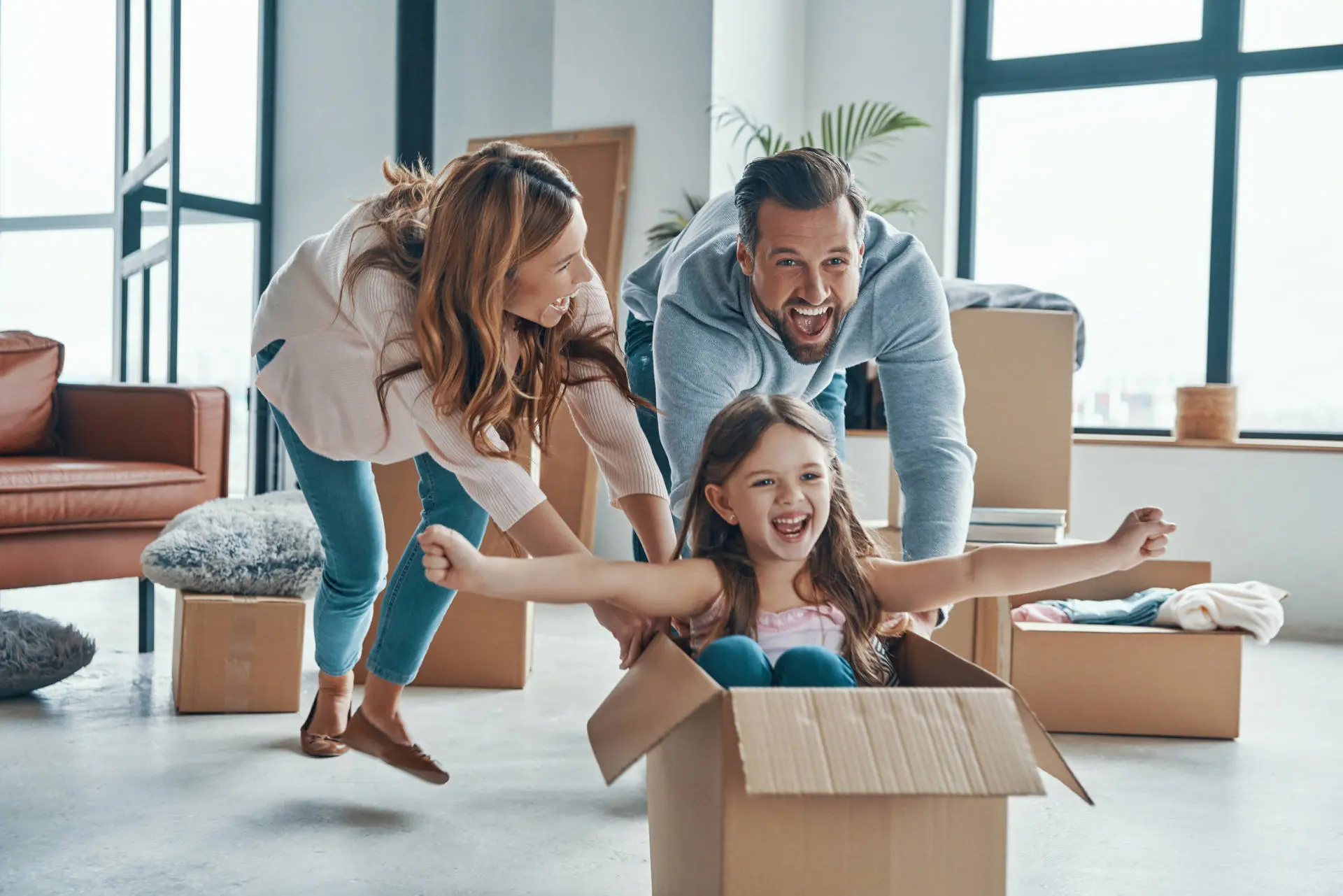 famille s'amusant dans des cartons déménagement