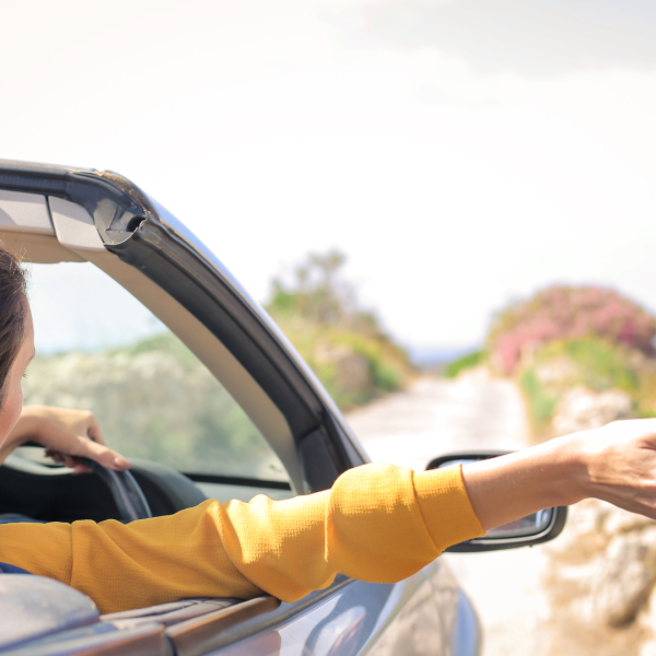 Photo femme voiture tendant la main par la fenêtre.