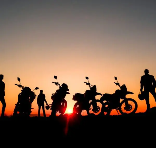 coucher de soleil avec plusieurs personnes et leur moto