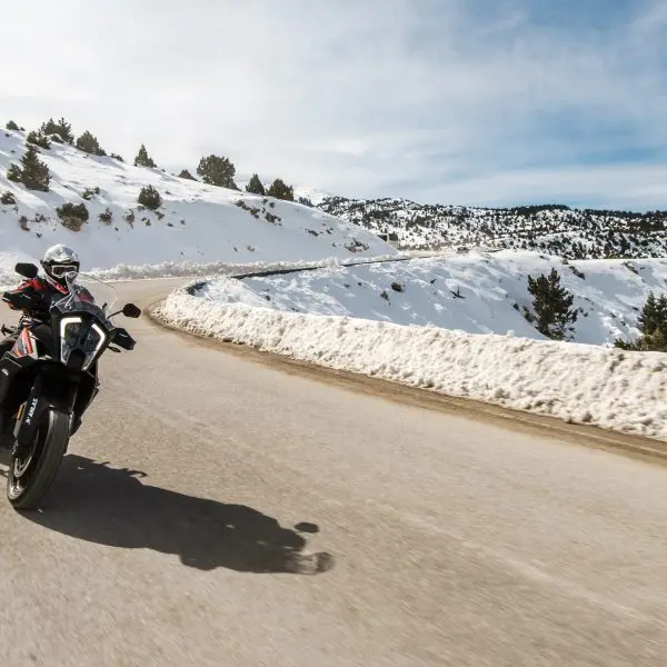 motard sur la route qui roule au bord de la neige