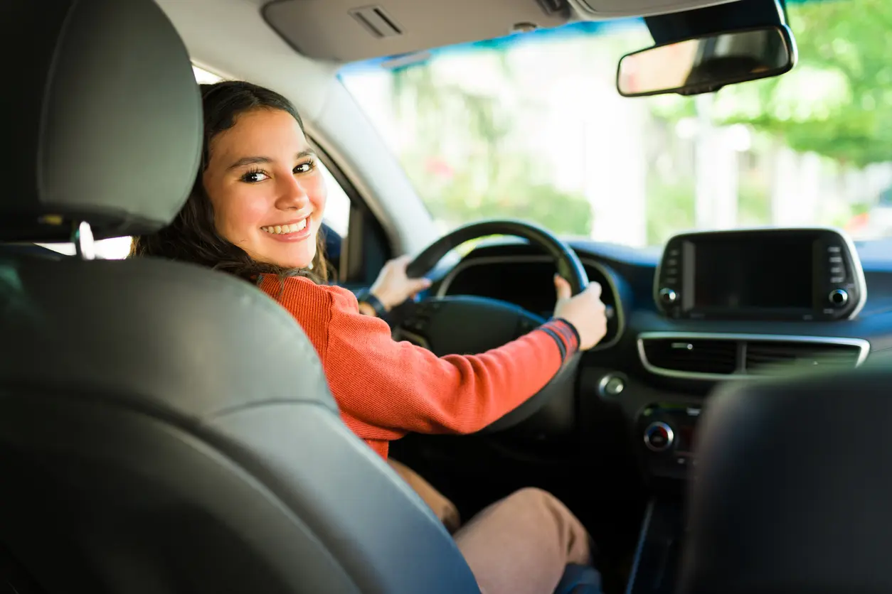 Jeune conductrice qui prends le volant de sa voiture sans permis