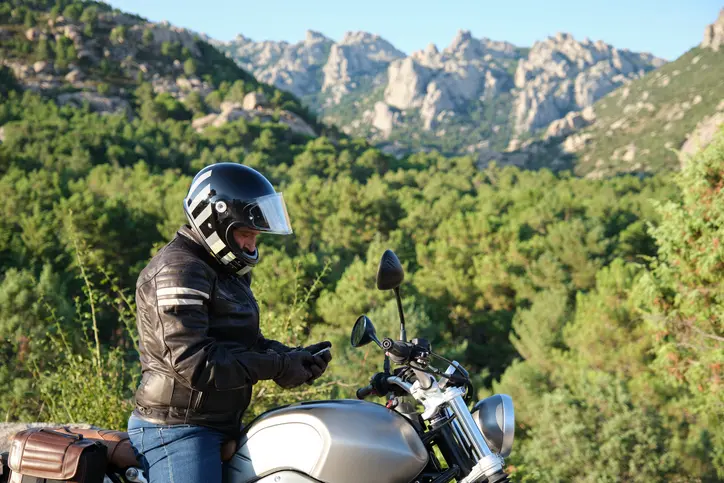 Motocycliste utilisant le téléphone portable dans la nature