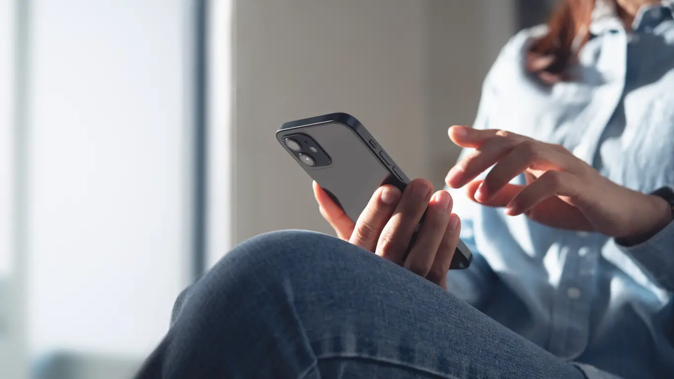 Jeune femme utilisant un téléphone portable pour faire un devis en ligne