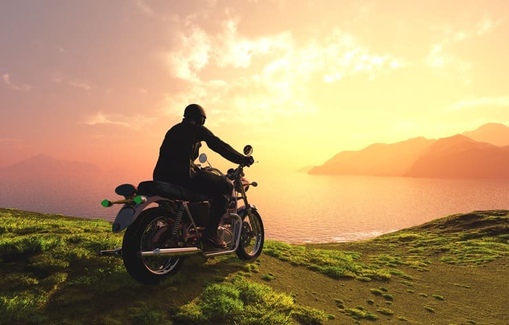 moto face à la mer au coucher de soleil