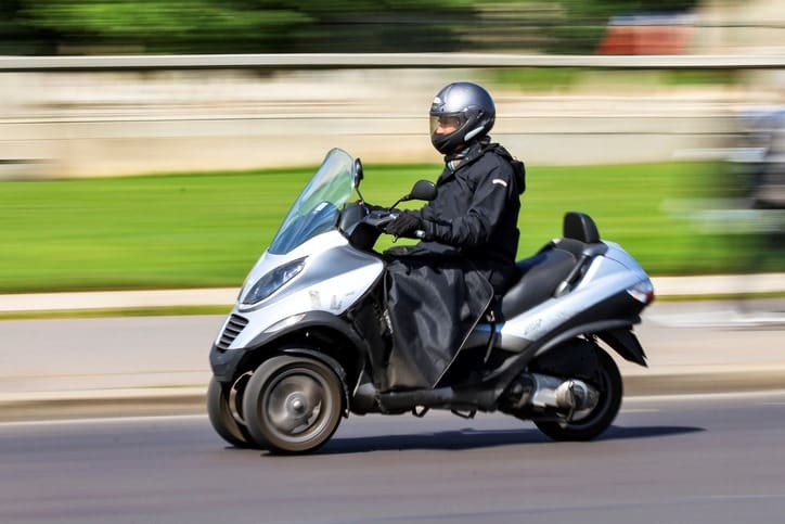 scooter 3 roues qui roule sur la route