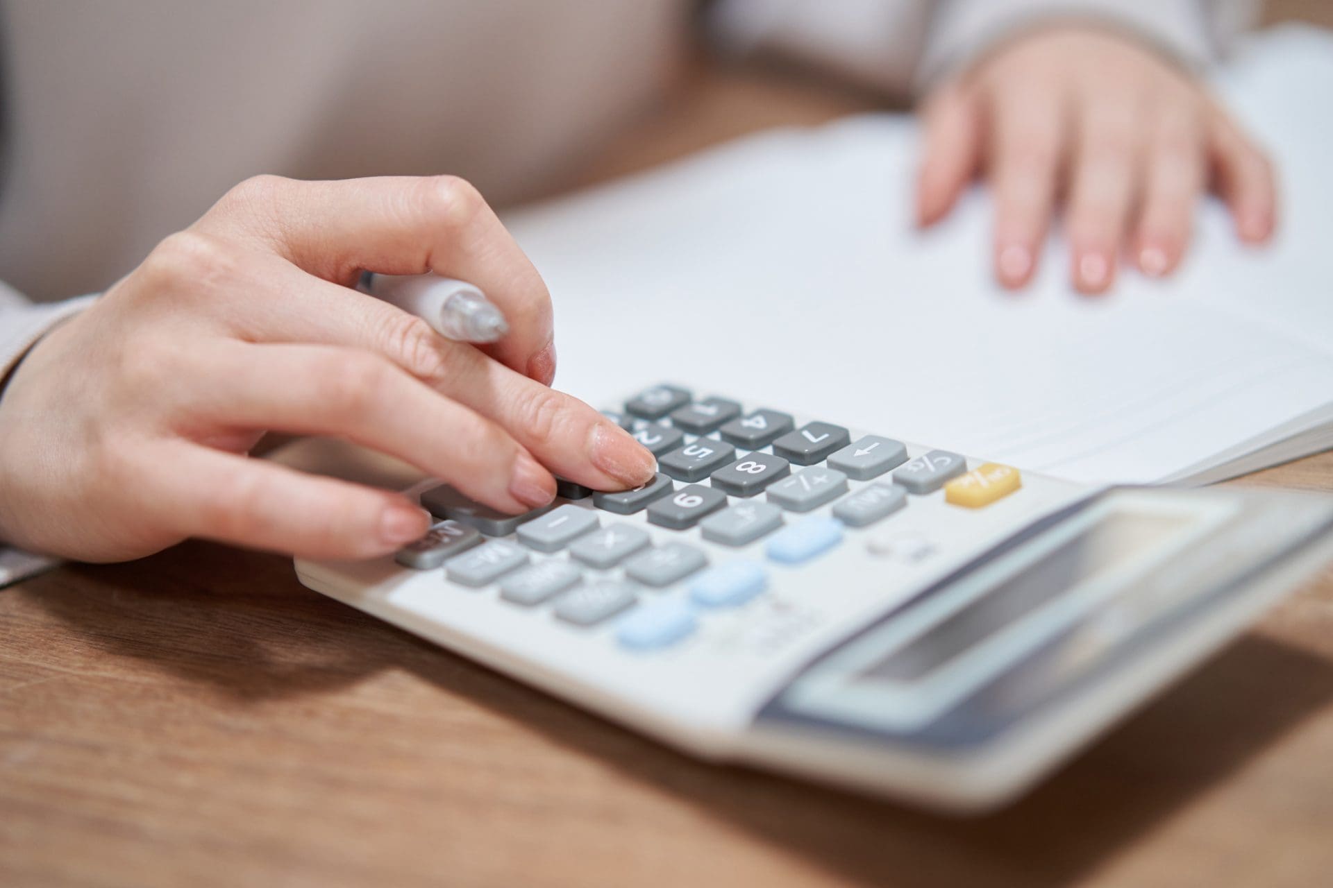 zoom d'une main en train de calculer avec l'aide d'une calculatrice.
