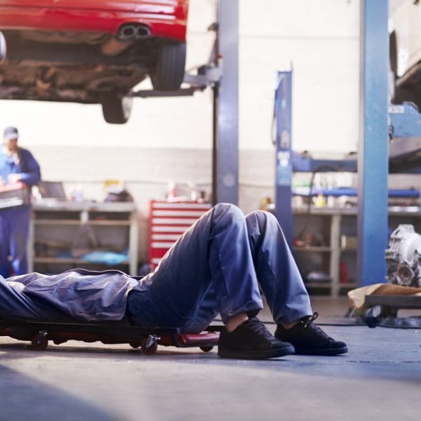 Mécanicien sous voiture dans un atelier de réparation automobile