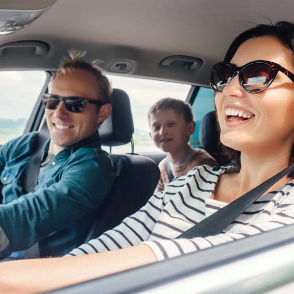 Trois personnes dans la voiture en train de sourire