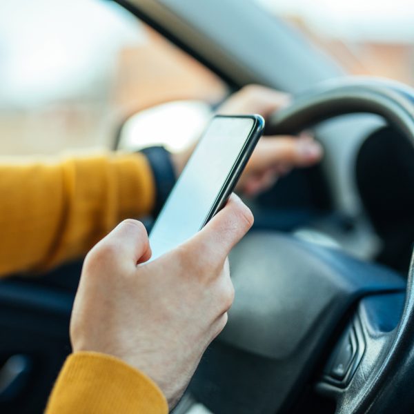 personne dans la voiture qui regarde son téléphone