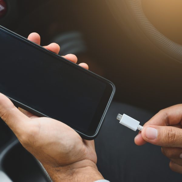 Personne qui charge son téléphone dans sa voiture