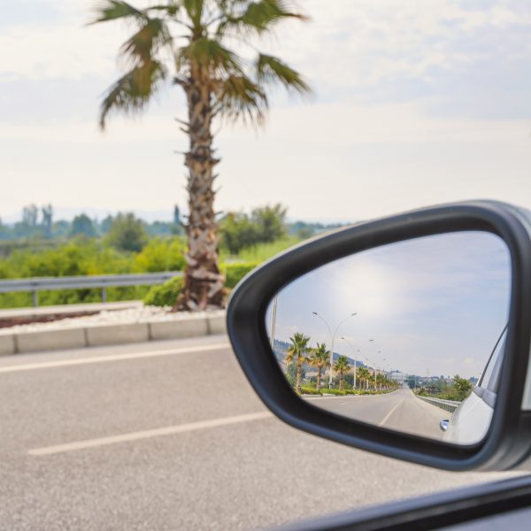 Reflet du soleil dans le rétroviseur latéral d’une voiture.