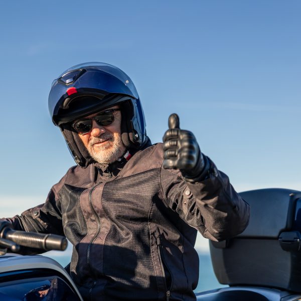 Un homme senior à moto donne un pouce levé pour un mode de vie heureux