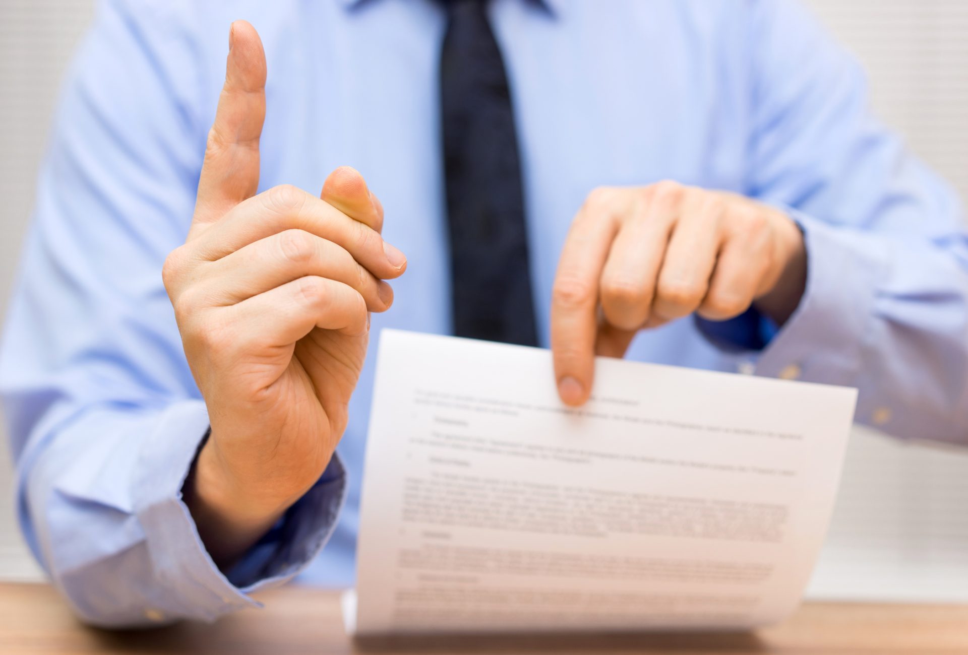 Personne qui pointe le doigt avec un document dans la main